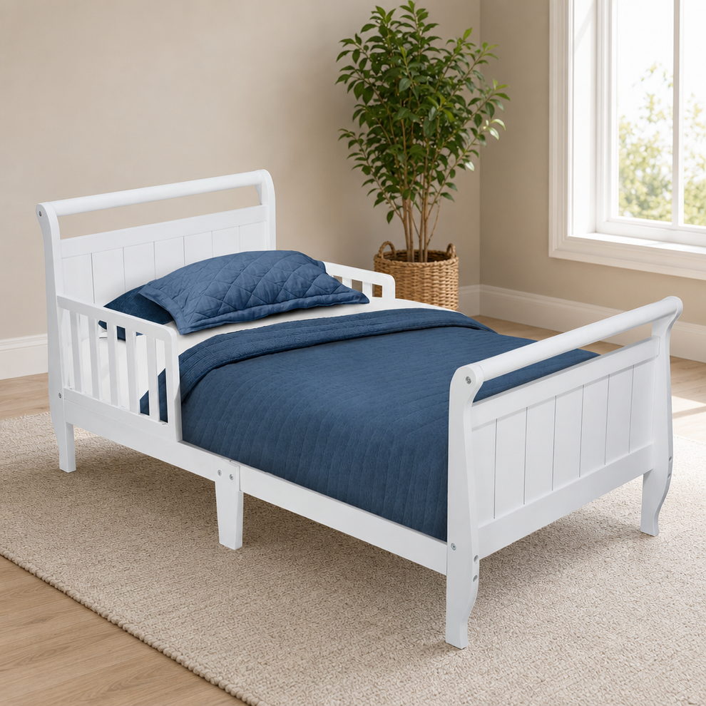 Delta Children Wood Sleigh Toddler Bed, White centered in a warm neutral furnished room