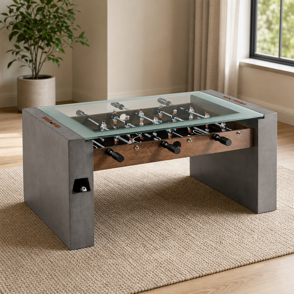 Foosball Coffee Table, 40 In. Tempered Glass Top, Faux Concrete Legs centered in a warm neutral furnished room