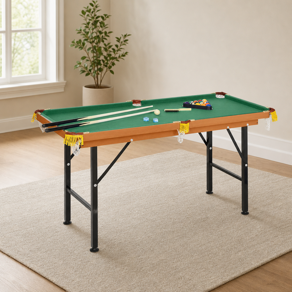 Mini Pool Table — Green Felt, Folding Legs, 6 Pockets, Includes Cues & Ball Set centered in a warm neutral furnished room