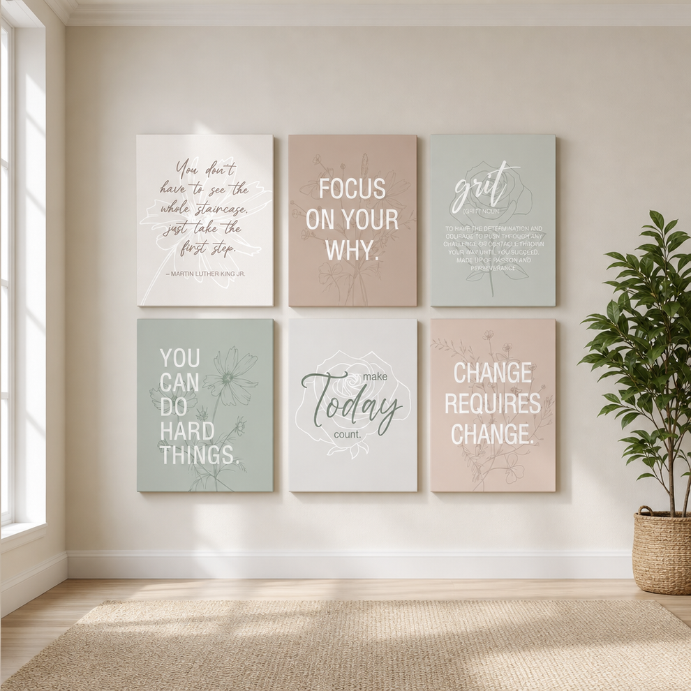 Six pastel motivational canvas prints arranged 2x3 on a beige wall with a woven rug and potted plant nearby