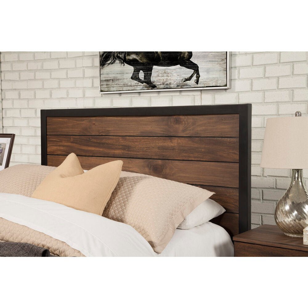 Angled close-up of the dark wood headboard beside a bedside table